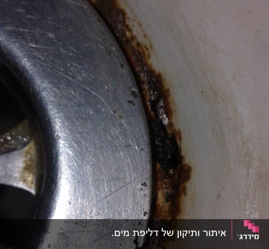 כיור מתכת עם חלודה ולכלוך סביב הניקוז